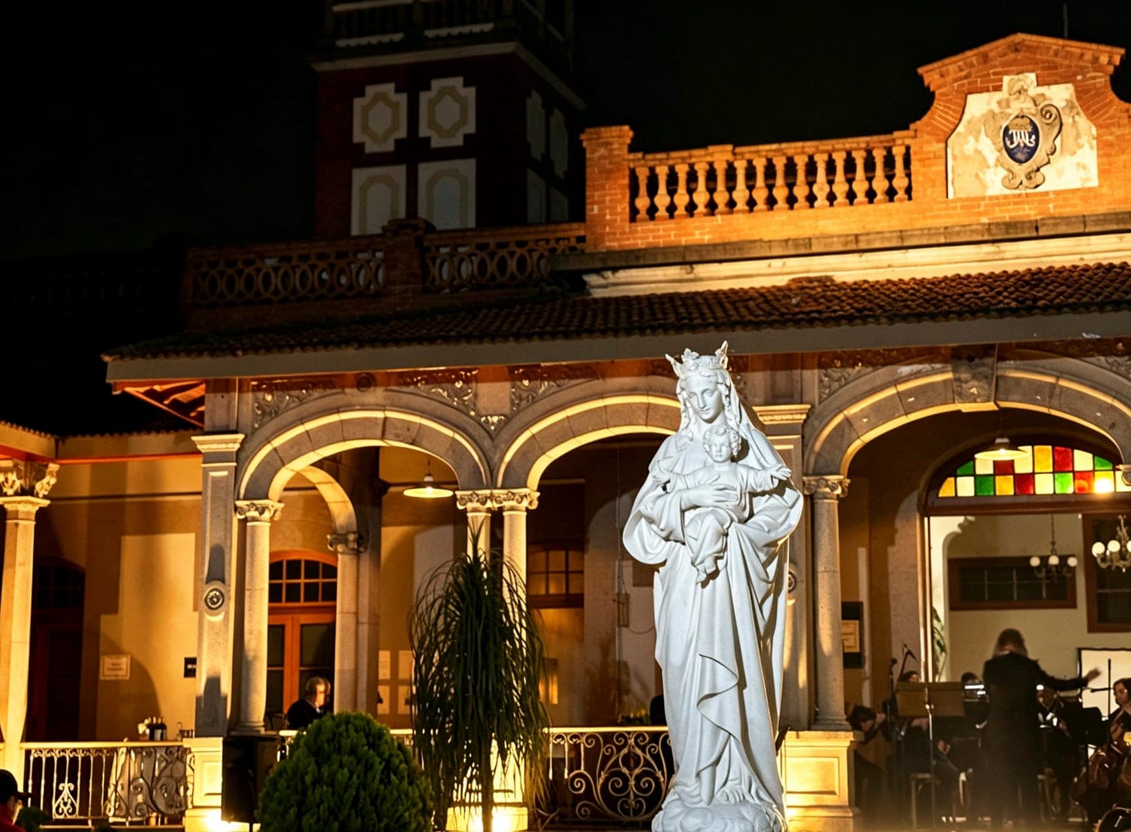 Escultura de la Virgen frente a los arcos iluminados de Quinta Soledad